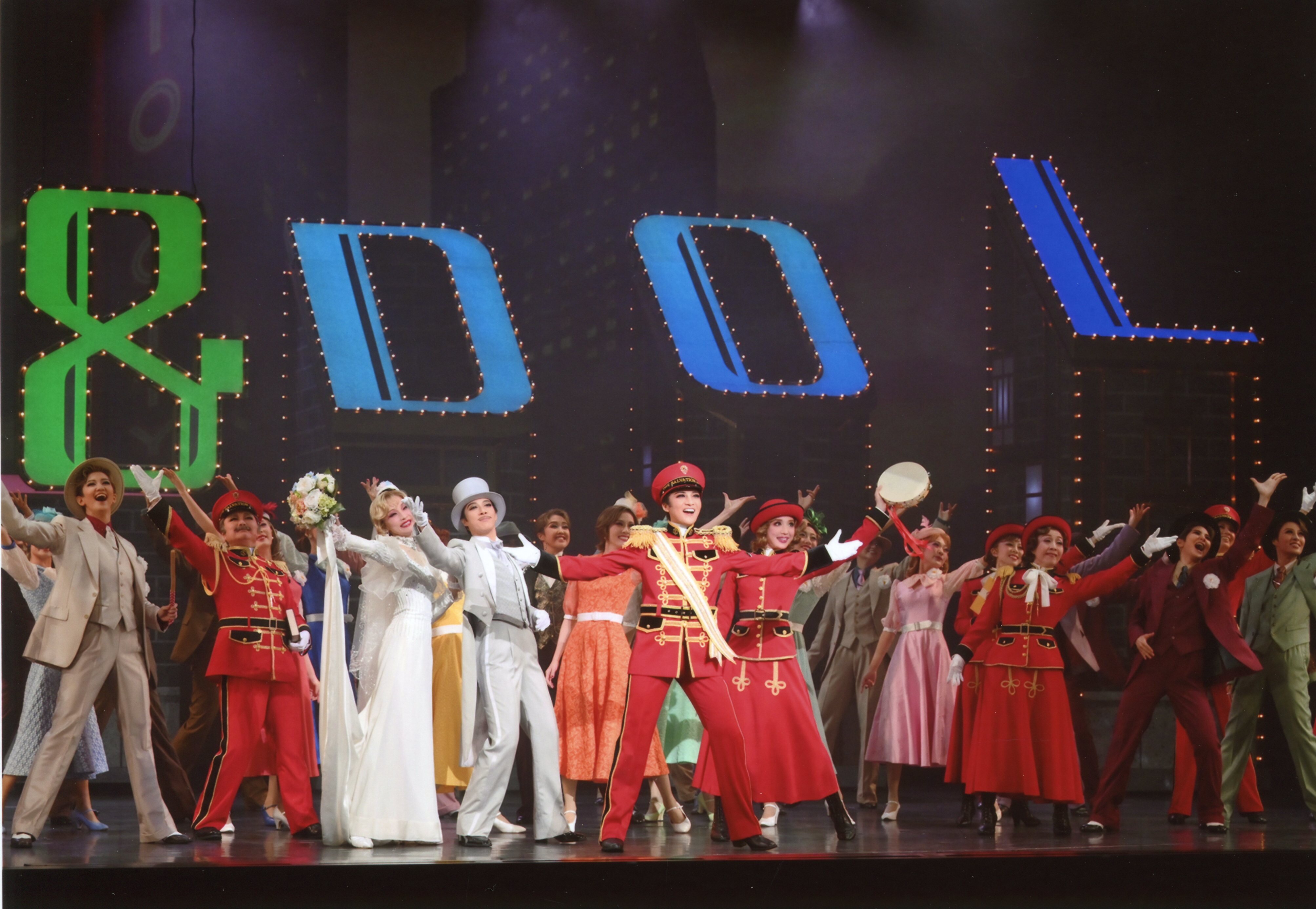 東京宝塚劇場公演の「ガールアンドドールズ」の公演中、キャストの複数人が手を広げている写真