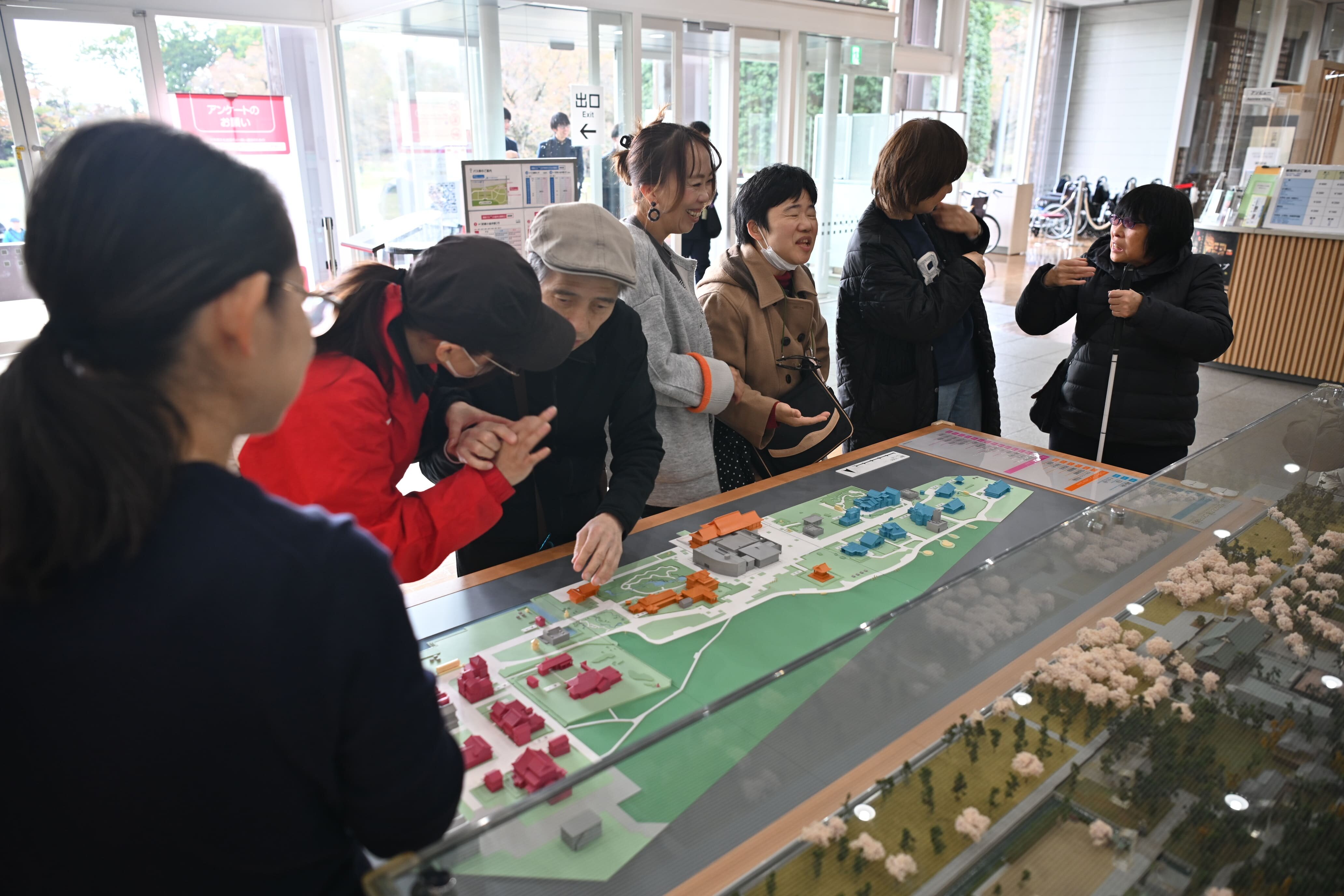 横幅2メートルぐらいのたてもの園全体の触察模型を触り確認する参加者の様子