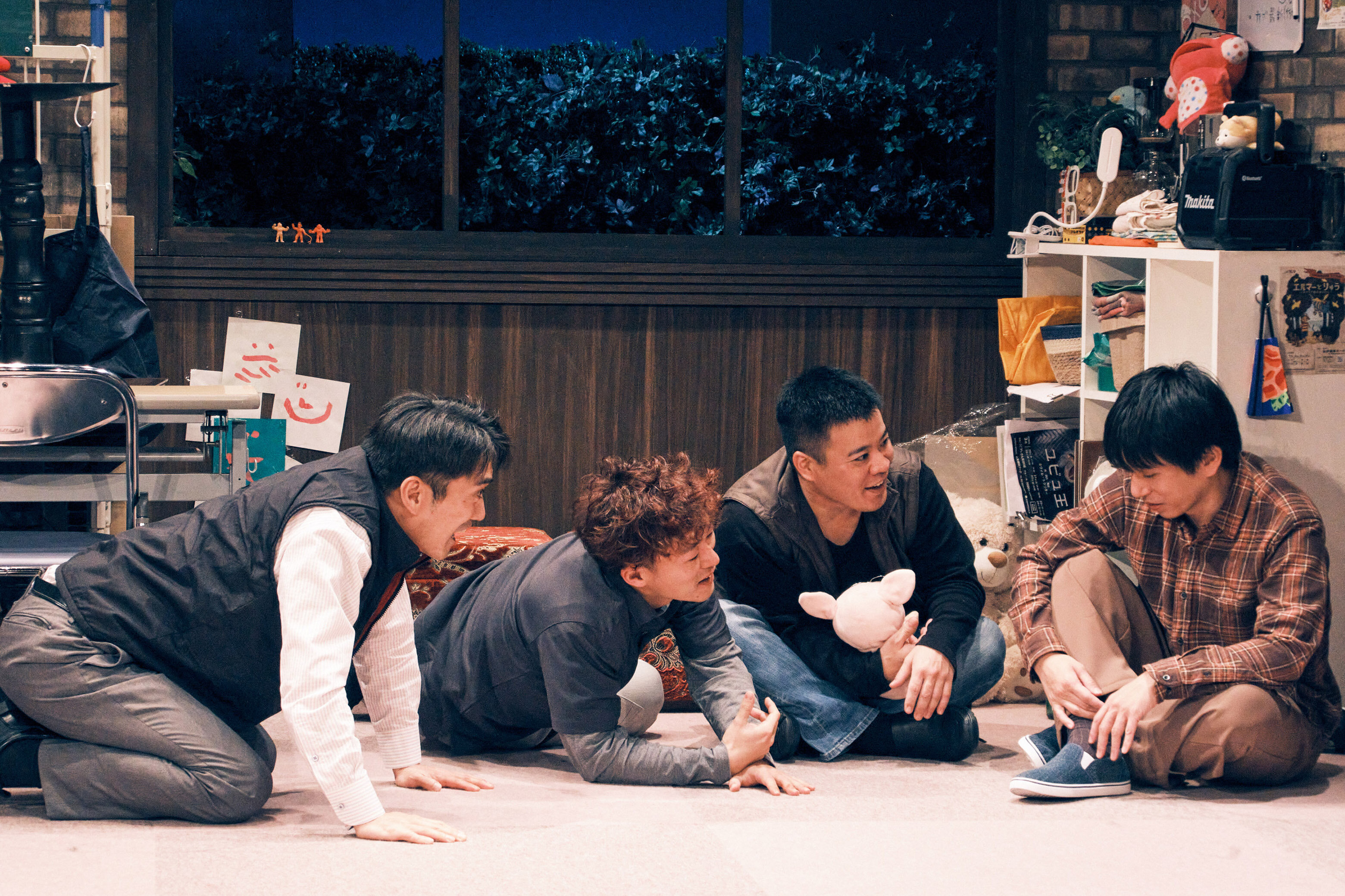 劇団ゴジゲンの演劇「きみがすきな日と」の公演で、舞台上で男性3人が寝ころび隣に座っている男性の話を聞いているシーンの写真