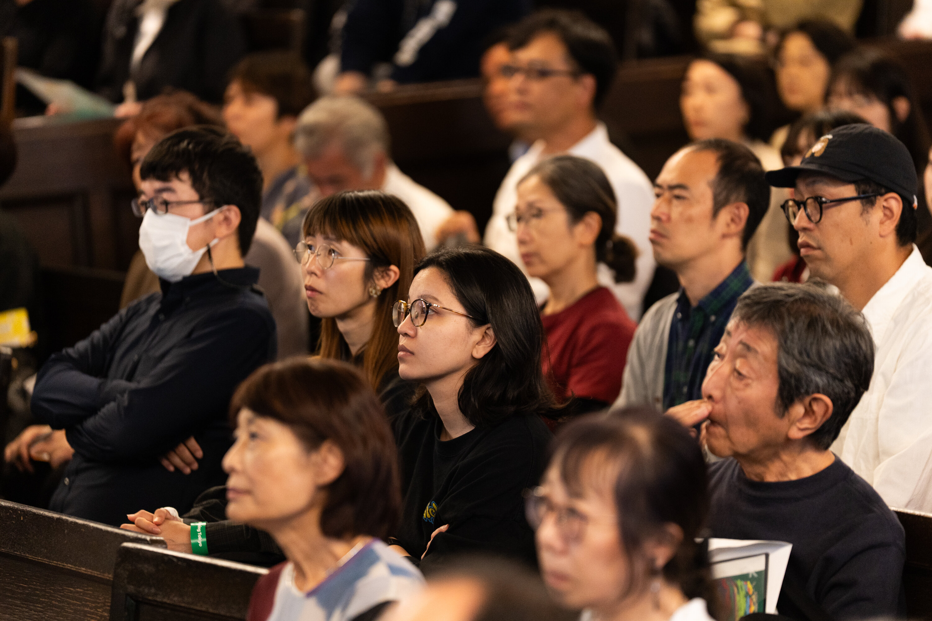 15名ほどの参加者が、舞台上にいる登壇者を見ながら説明を真剣に聞いている。